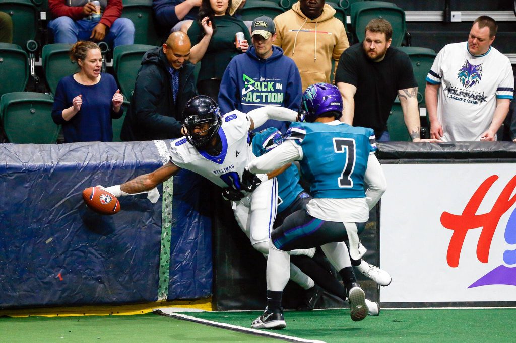 Outlaws receiver Karonce Higgins reaches over the line for a touchdown during the Washington Wolfpacks inaugural home opener against Billings on Sunday, May 5, 2024, a Angel of the Winds Arena in Everett, Washington. (Ryan Berry / The Herald)