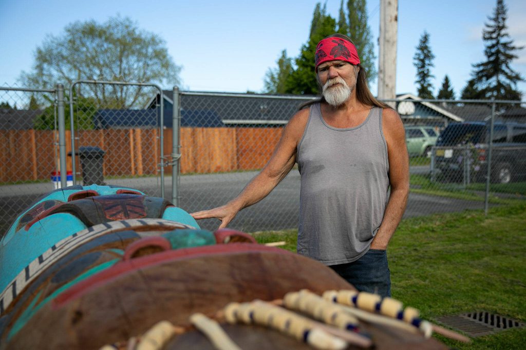Tlingit Artist Fred Fulmer stands by one of his completed totem poles on Wednesday, May 8, 2024, at his home in Everett, Washington. This pole is not the one being sent to Alaska. (Ryan Berry / The Herald)