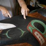 Tlingit Artist Fred Fulmer points to some of the texture work he did on his information totem pole on Wednesday, May 8, 2024, at his home in Everett, Washington. (Ryan Berry / The Herald)