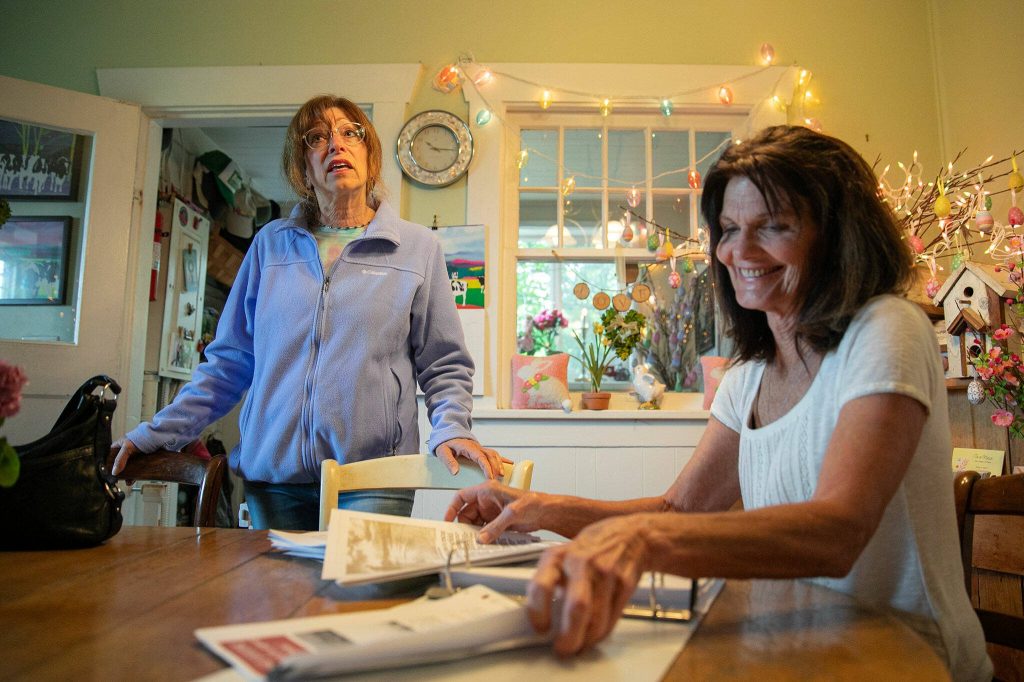 Snohomish residents Beth Jarvis, left, and Barbara Bailey come together in Baileys kitchen to talk about their position against the expansion of Harvey Airfield on Monday, May 13, 2024, in Snohomish, Washington. (Ryan Berry / The Herald)
