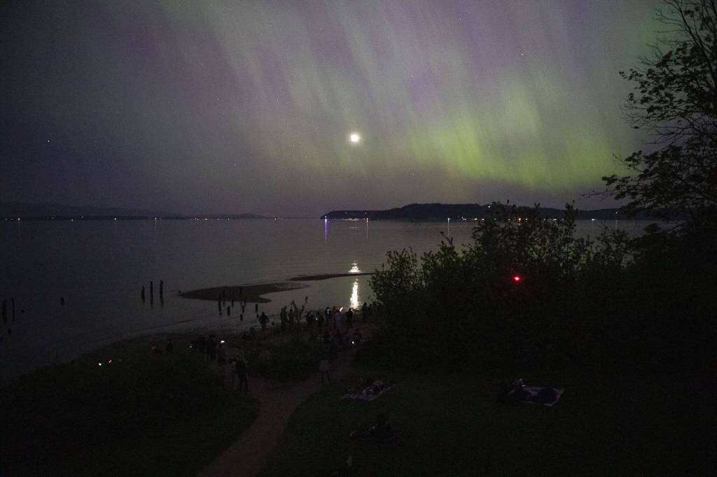 Hundreds of people gather to watch an aurora at Picnic Point Park in Edmonds, Washington on Friday, May 10, 2024. (Annie Barker / The Herald)