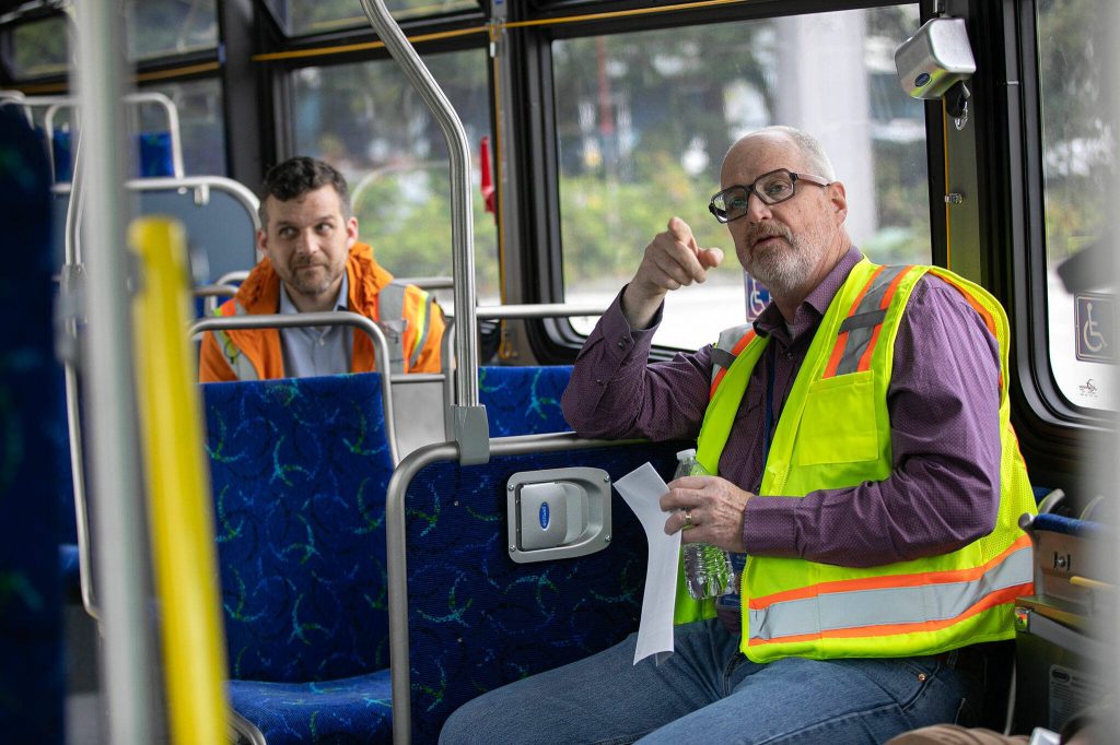 Community Transit CEO Ric Ilgenfritz, right, speaks with other Community Transit leaders during an interview with the Herald on a new electric bus Monday, May 13, 2024, at the Community Transit Operations Base in Everett, Washington. (Ryan Berry / The Herald)