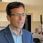 Attorney General Bob Ferguson speaks to a reporter as his 2024 gubernatorial campaign launch event gets underway in Seattle, on Saturday, Sept. 9, 2023. ( Jerry Cornfield/Washington State Standard)