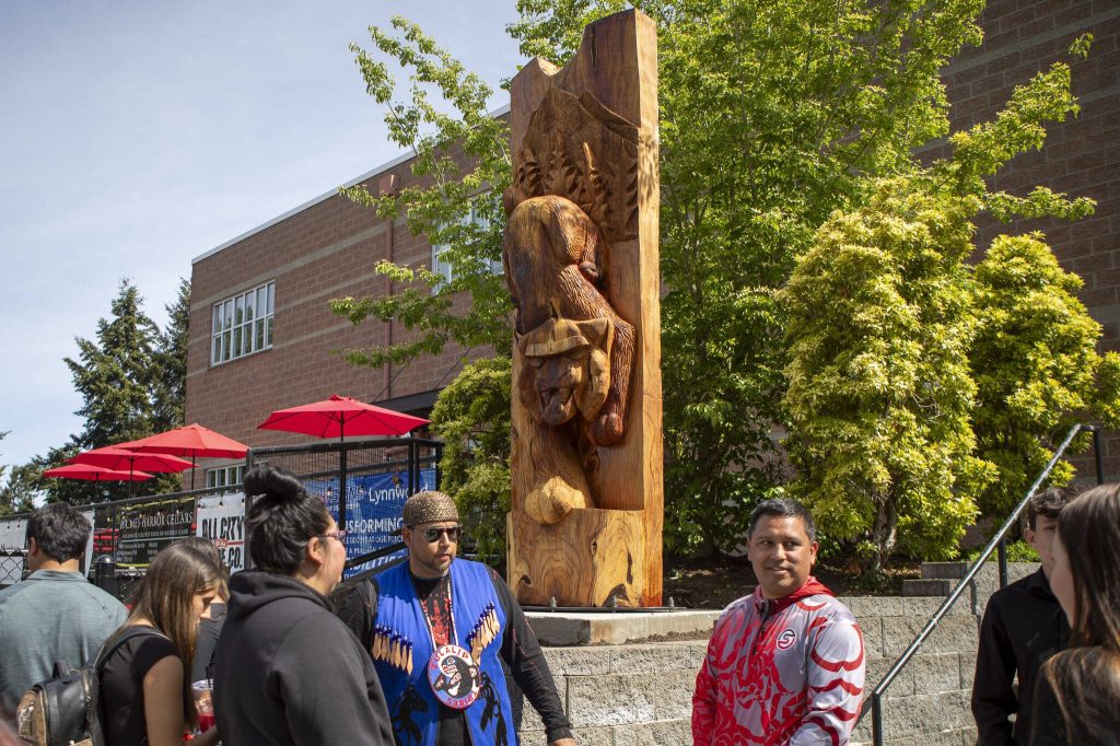 People gather to view the healing pole students spent the last year carving along with Tulalip carver James Madison at Archbishop Murphy High School in Everett, Washington on Wednesday, May 15, 2024. (Annie Barker / The Herald)