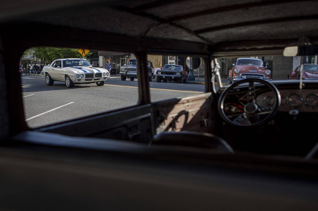 Cars drive around during the Cruzin to Colby event in downtown Everett, Washington on Sunday, May 28, 2023. (Annie Barker / The Herald)