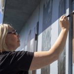 Gina Ribaudo works on a mural at the intersection of Colby and Pacific for the Imagine Childrens Museum in Everett, Washington on Thursday, May 9, 2024. (Annie Barker / The Herald)