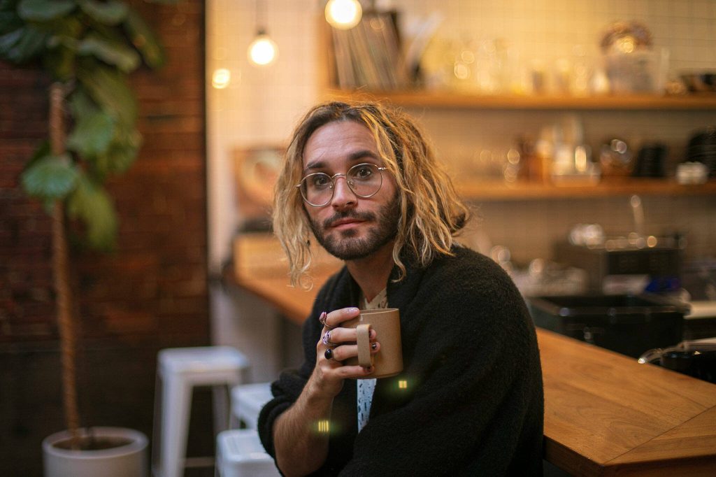 Local musician Alex Johnston, whose newest album Daylight Fooldream pairs with short film he made with help from his partner Mikaela Henderson, sits with his morning coffee on Friday, Sept. 15, 2023, at Narrative Coffee in Everett, Washington. (Ryan Berry / The Herald)
