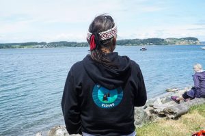 Tony Cladusbid, co-owner of the Beaver Tales Coffee franchise, watches over the canoe racing at the Penn Cove Water Festival on Saturday. (Photo by Sam Fletcher)