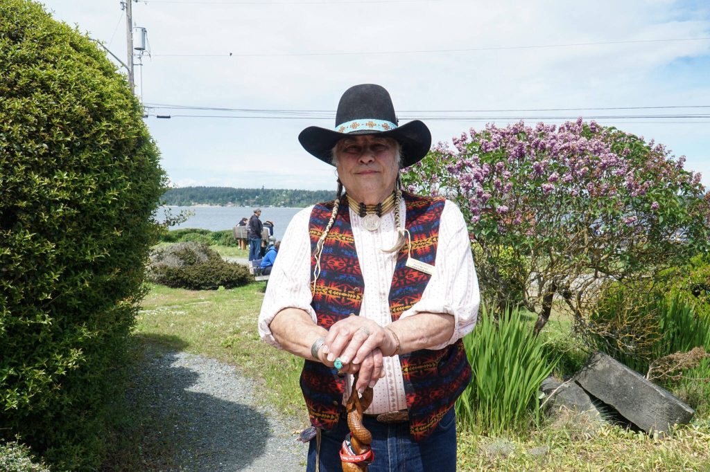 Storyteller Lou LaBombard stands before the Island County Historical Museum on Saturday. (Photo by Sam Fletcher)