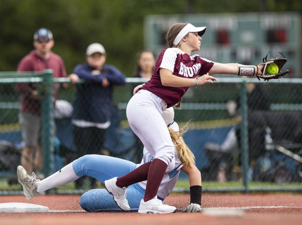 Cascades Kodie Rasmussen reached for a throw as a Gig Harbor player slides into third base during the 3A state softball tournament game against Gig Harbor on Thursday, May 23, 2024 in Lacey, Washington. (Olivia Vanni / The Herald)