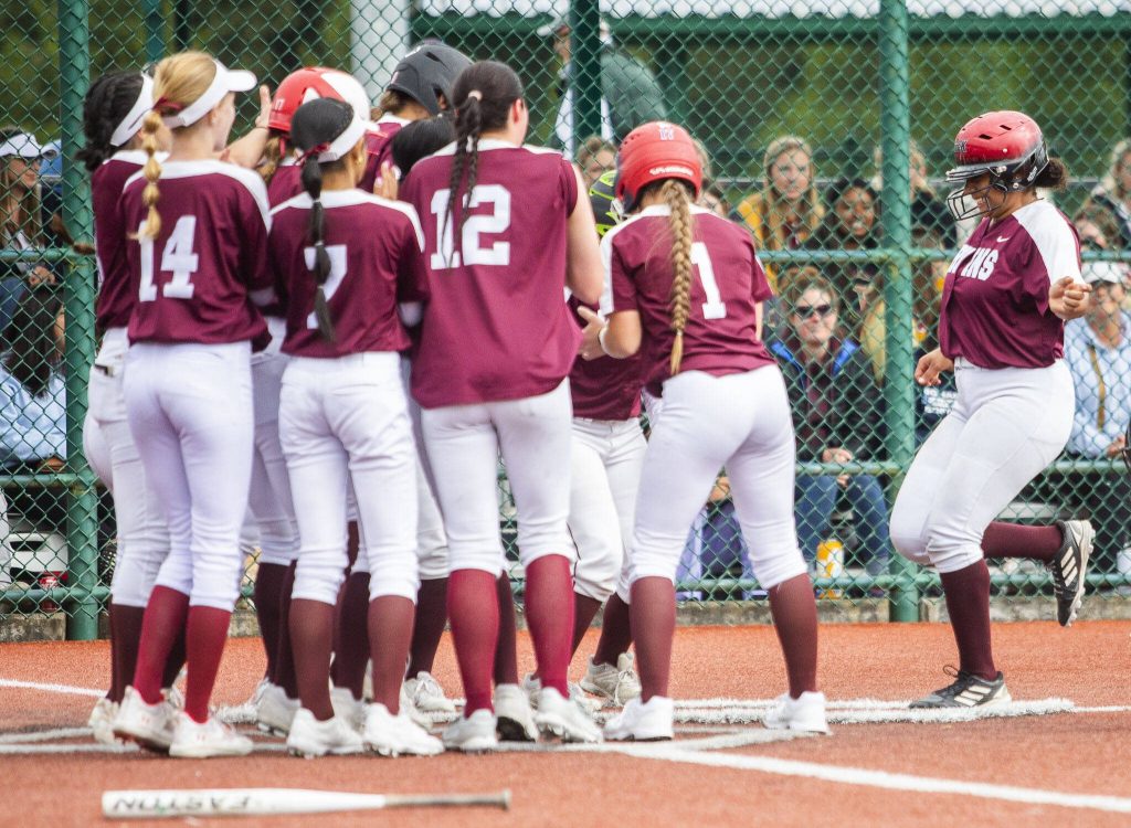 Cascade players celebrate as teammate Jaidyn Wilson runs into home plate after her grand slam during the 3A state softball tournament game against Gig Harbor on Thursday, May 23, 2024 in Lacey, Washington. (Olivia Vanni / The Herald)