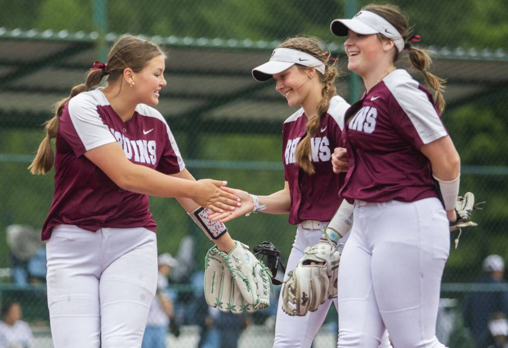 Cascades Mia Walker, left, high-fives teammate Tessa Hahn after an out during the 3A state softball tournament game against Gig Harbor on Thursday, May 23, 2024 in Lacey, Washington. (Olivia Vanni / The Herald)