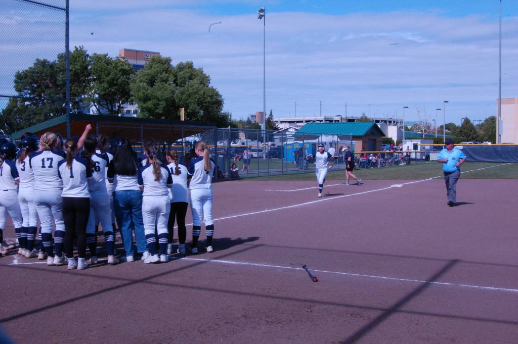 Glacier Peak softball teammates await Samantha Christensen after her 2-run homer put the Grizzles up 2-0 in a consolation game against Eastmont in the Class 4A state playoffs May 24 at Columbia Playfields in Richland, WA (Aaron Coe / The Herald).