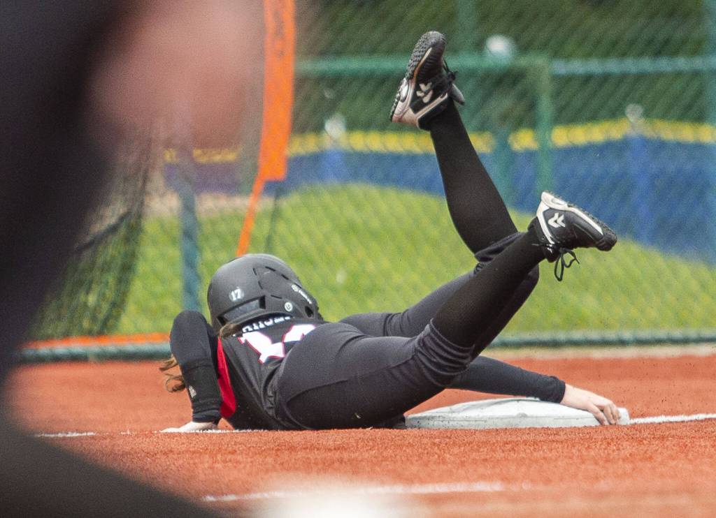 Snohomishs Madalynn Larsen grabs onto third base to avoid sliding past it during the 3A state softball semifinal game against Garfield on Saturday, May 25, 2024 in Lacey, Washington. (Olivia Vanni / The Herald)