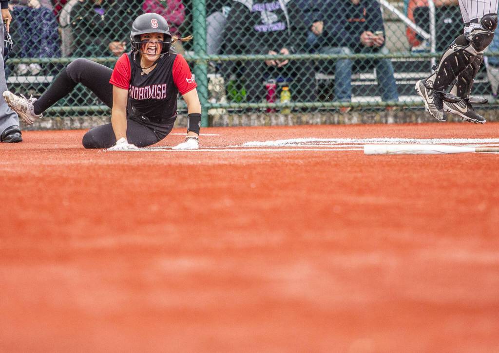 Snohomishs Alexandra Flohr yells as she slides across home plate to score during the 3A state softball semifinal game against Garfield on Saturday, May 25, 2024 in Lacey, Washington. (Olivia Vanni / The Herald)