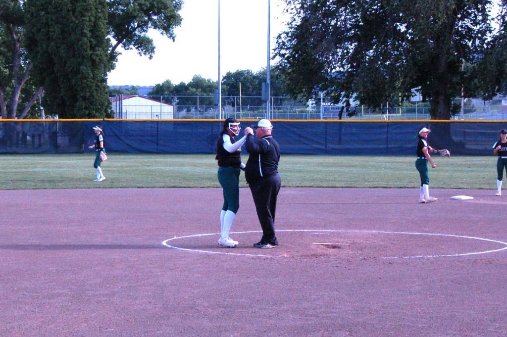 Retiring Jackson softball first base coach Ken Hudson has his customary pre-inning meeting with starting pitcher Yanina Sherwood for the final time to start the bottom of the seventh inning of the Class 4A state championship game at Columbia Playfield (Aaron Coe / The Herald)
