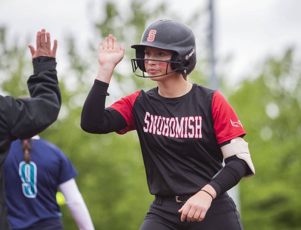 Snohomishs Abby Edwards high-fives a coach after getting a base hit during the 3A state softball championship game against Auburn Riverside on Saturday, May 25, 2024 in Lacey, Washington. (Olivia Vanni / The Herald)