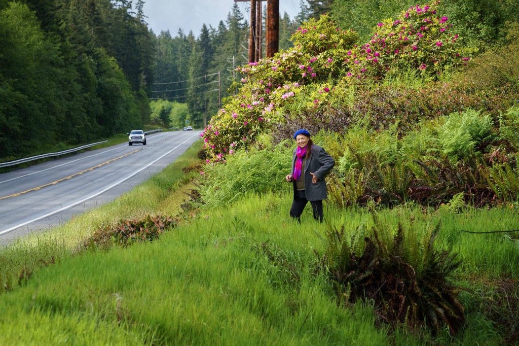 Greenbank resident Kristi ODonnell visits a patch of rhododendrons at the side of Highway 525 that she helped save nearly 20 years ago. (Photo by David Welton)