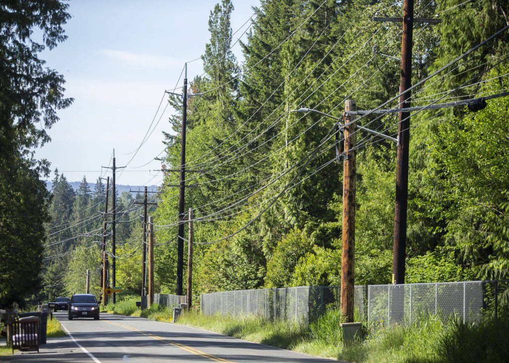 Cars drives along 103rd Avenue SE past power lines on Friday, May 31, 2024 in Lake Stevens, Washington. (Olivia Vanni / The Herald)