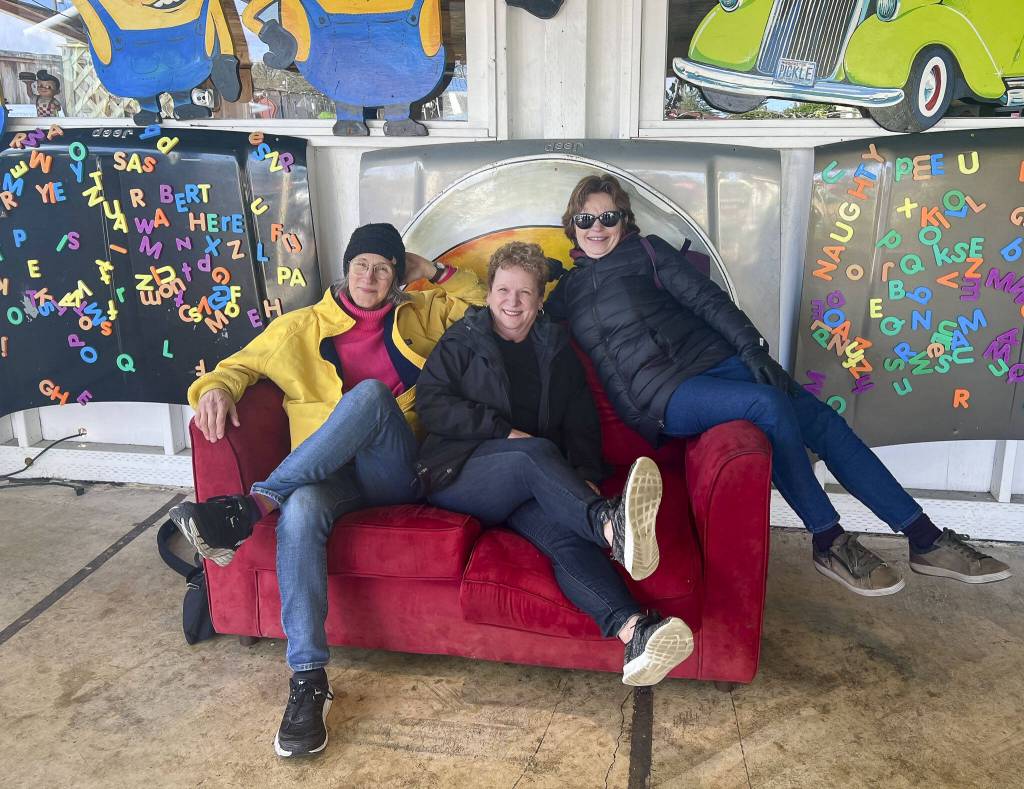 Daily Herald colleagues Brenda Mann Harrison, left, Andrea Brown, center, and Janice Podsada, right, began their razor clamming adventure from the Everett area in Washington to the Pacific Coast on March 13. Their first stop on the road was Eastside Big Tom, a landmark burger destination in Olympia, with a dinosaur and retro theme. (Jacqueline Allison / Special to The Herald)