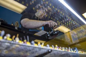 Colt Candland dusts off a hearse above available minifigures at Bricks and Minifigs in Everett, Washington on Thursday, May 30, 2024. (Annie Barker / The Herald)