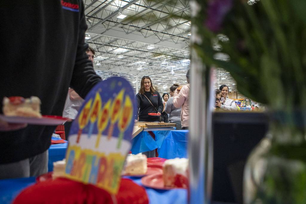 People eat cake and pizza on Friday, May 31, 2024, during a first birthday party at Costco in Lake Stevens. (Annie Barker / The Herald)