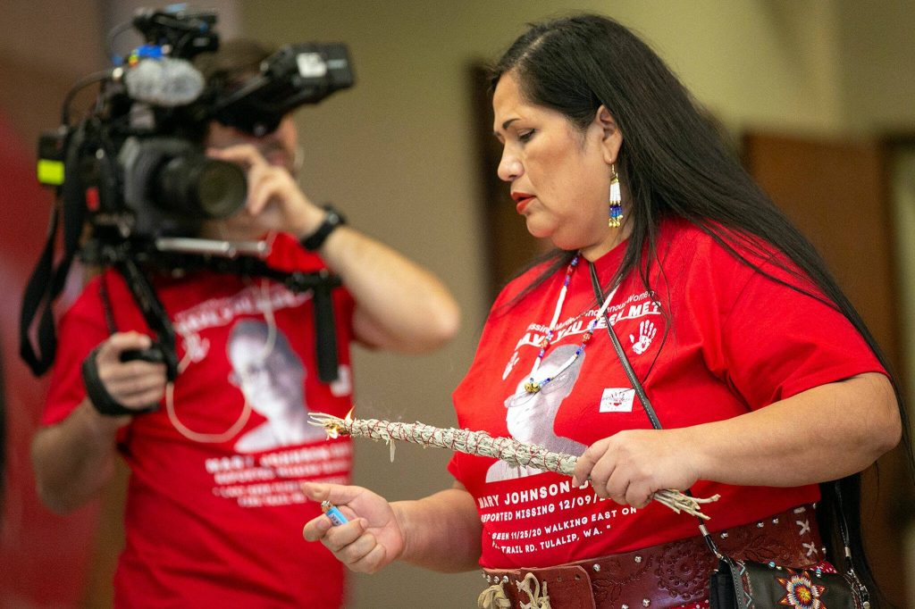 Event organizer Roxanne White lights a smudge stick as the family of Mary Ellen Johnson-Davis step up to the microphone to give a statement on Sunday, Dec. 11, 2022, at Daybreak Star Indian Cultural Center in Seattle, Washington. (Ryan Berry / The Herald)
Event organizer Roxanne White lights a smudge stick as the family of Mary Ellen Johnson-Davis step up to the microphone to give a statement on Sunday, Dec. 11, 2022, at Daybreak Star Indian Cultural Center in Seattle, Washington. (Ryan Berry / The Herald)