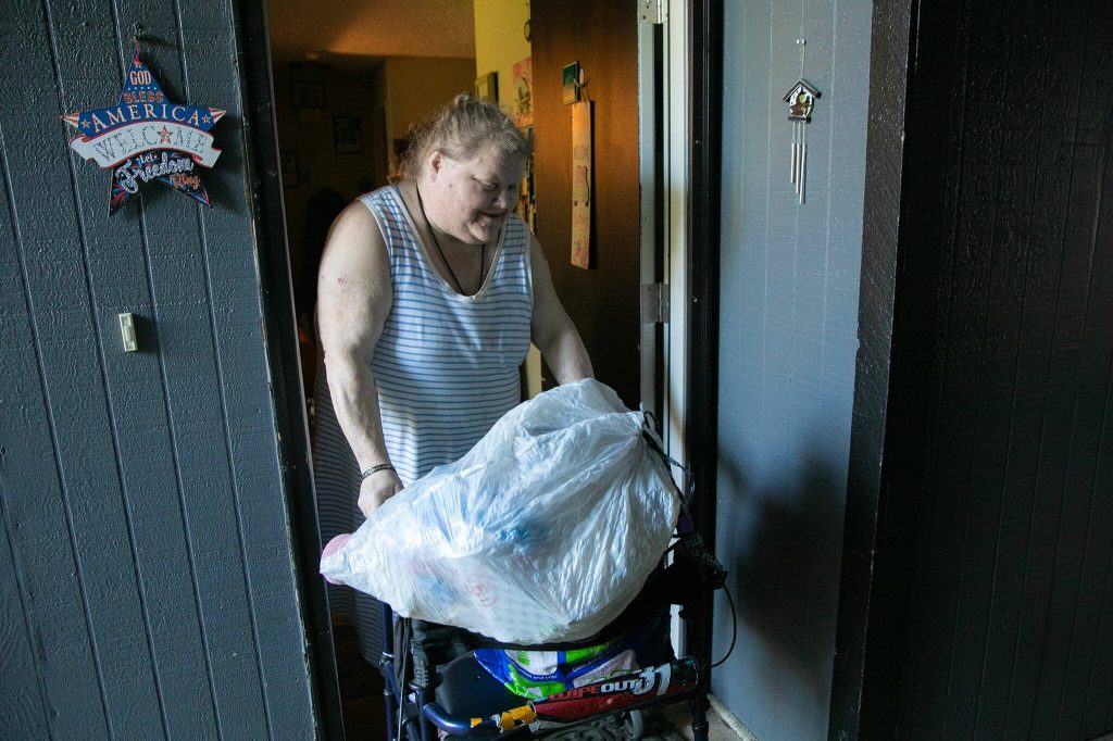 Jeanette Merkey, 54, exits her apartment to go take out the trash and recycling on Friday, June 7, 2024, in Everett, Washington. (Ryan Berry / The Herald)