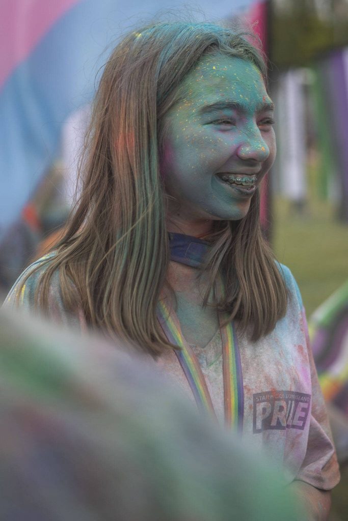 People participate in the color throw event involving colorful packets of corn starch during the Stanwood-Camano Pride event at Freedom Park in Camano, Washington on Saturday, June 1, 2024. (Annie Barker / The Herald)