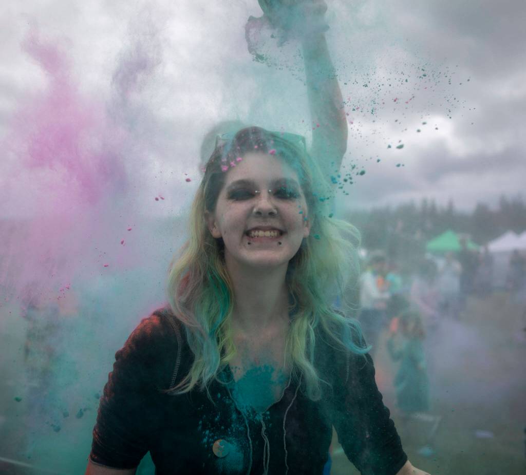 People participate in the color throw event involving colorful packets of corn starch during the Stanwood-Camano Pride event at Freedom Park in Camano, Washington on Saturday, June 1, 2024. (Annie Barker / The Herald)