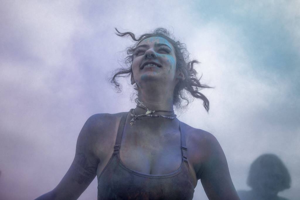 Chrissy Cherry participates in the color throw event involving colorful packets of corn starch during the Stanwood-Camano Pride event at Freedom Park in Camano, Washington on Saturday, June 1, 2024. (Annie Barker / The Herald)