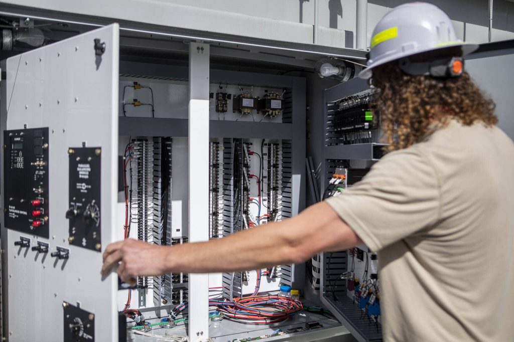 PUD employee Kyle Tucker discusses what sections of wiring does at the Jennings Park Substation in Marysville, Washington on Wednesday, June 5, 2024. (Annie Barker / The Herald)