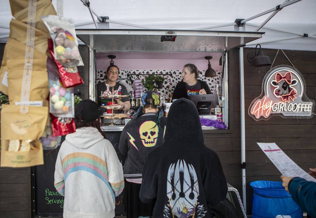Melinda Grenier, left, and Audrey Blomberg, right, serve patrons at Hay Girl Coffee during the third annual Arlington Pride event in Arlington, Washington on Sunday, June 2, 2024. (Annie Barker / The Herald)