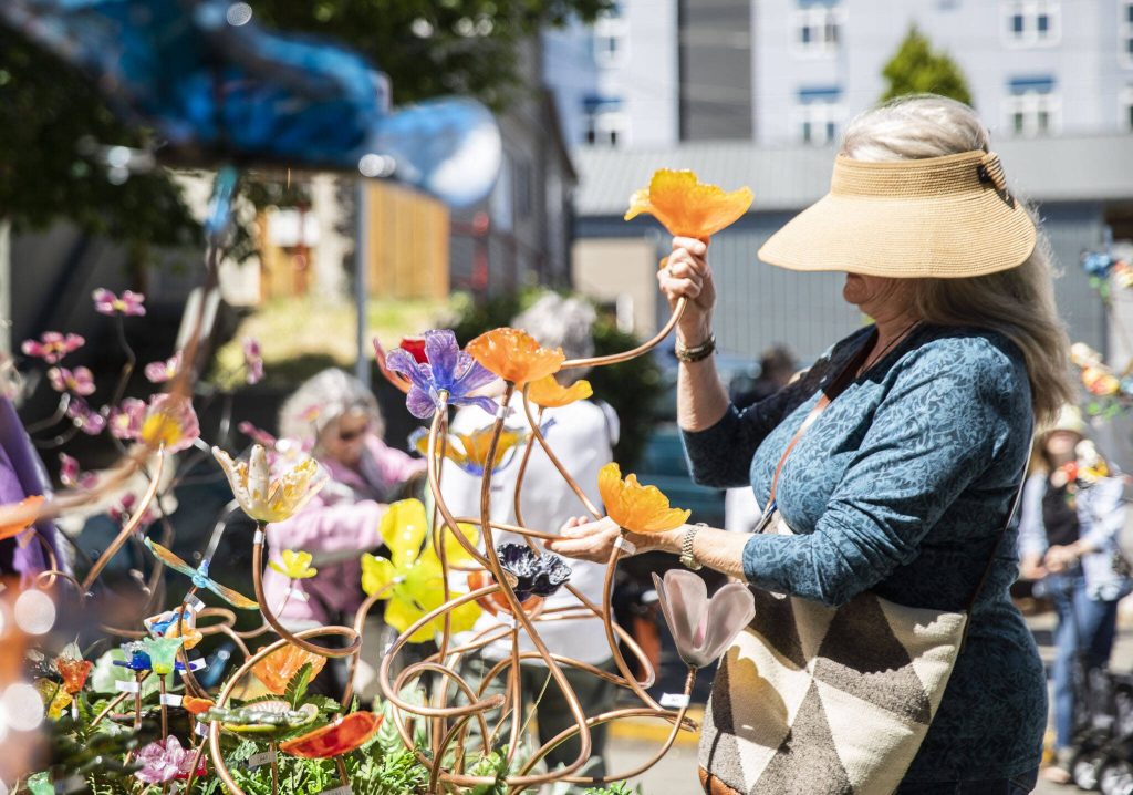 A woman picks out a glass flower from FUSE4U during Sorticulture on Friday, June 7, 2024, in Everett, Washington. (Olivia Vanni / The Herald)