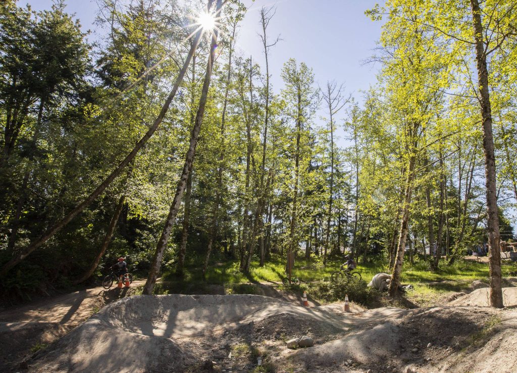 A pair of bikers ride around the perimeter of the new Mukilteo Bike Park on Wednesday, June 12, 2024 in Mukilteo, Washington. (Olivia Vanni / The Herald)