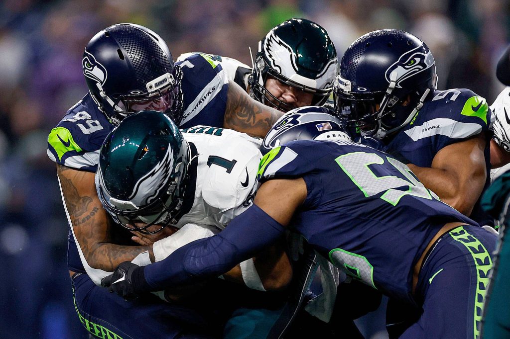 Eagles quarterback Jalen Hurts gets stopped by Seattle Seahawks defensive end Leonard Williams (99) and linebacker Bobby Wagner (54) on Dec. 18, 2023, at Lumen Field in Seattle. (Yong Kim / The Philadelphia Inquirer, file)