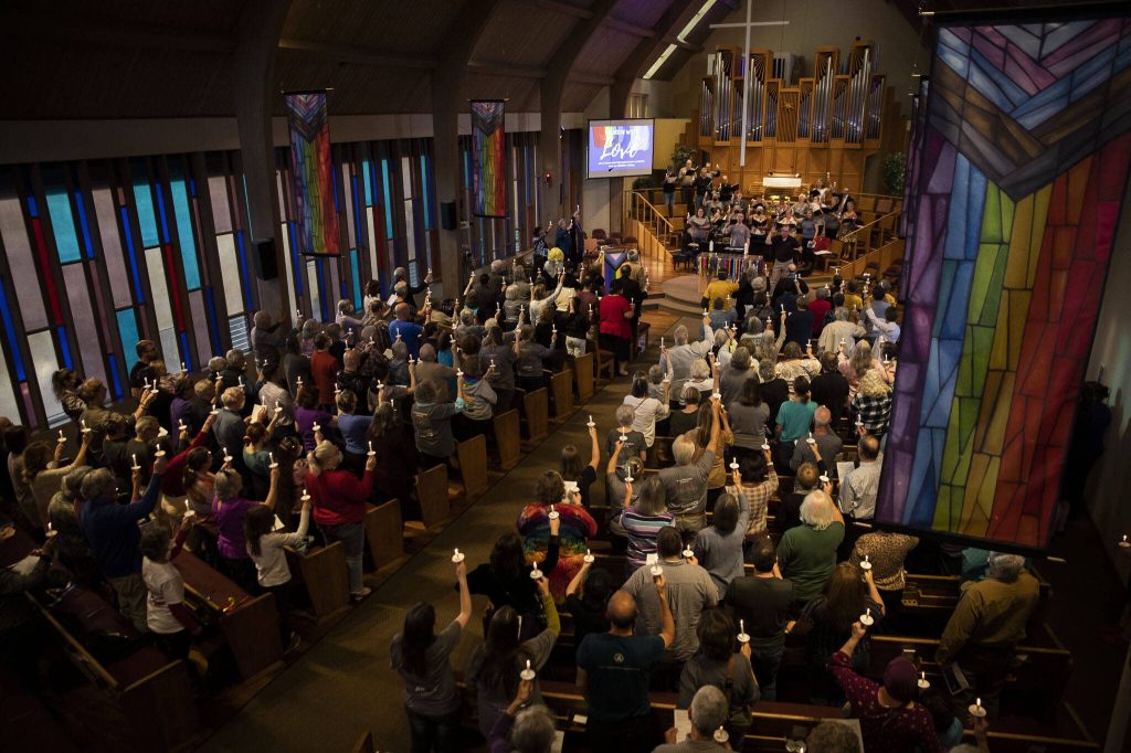 Attendees raise up candles during a vigil held at Edmonds United Methodist Church to show support of the LGBTQIA+ community in response to the recent hate-filled incidents at two regional churches on Tuesday, May 2, 2023, in Edmonds, Washington. (Olivia Vanni / The Herald)
