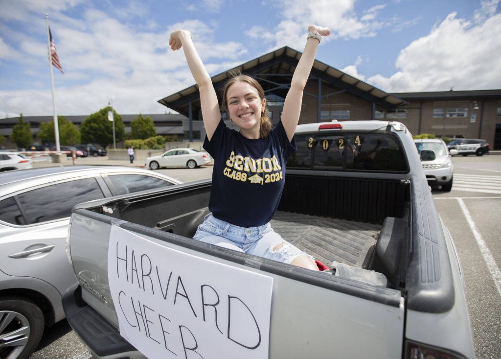 Arlington High School senior Alyssa Acosta sits in the back of her mother’s truck still decorated from the senior parade on Wednesday, June 12, 2024 in Arlington, Washington. Acosta, who has been cheering for 8 years, will be attending Harvard in the fall on a full cheer scholarship. (Olivia Vanni / The Herald)