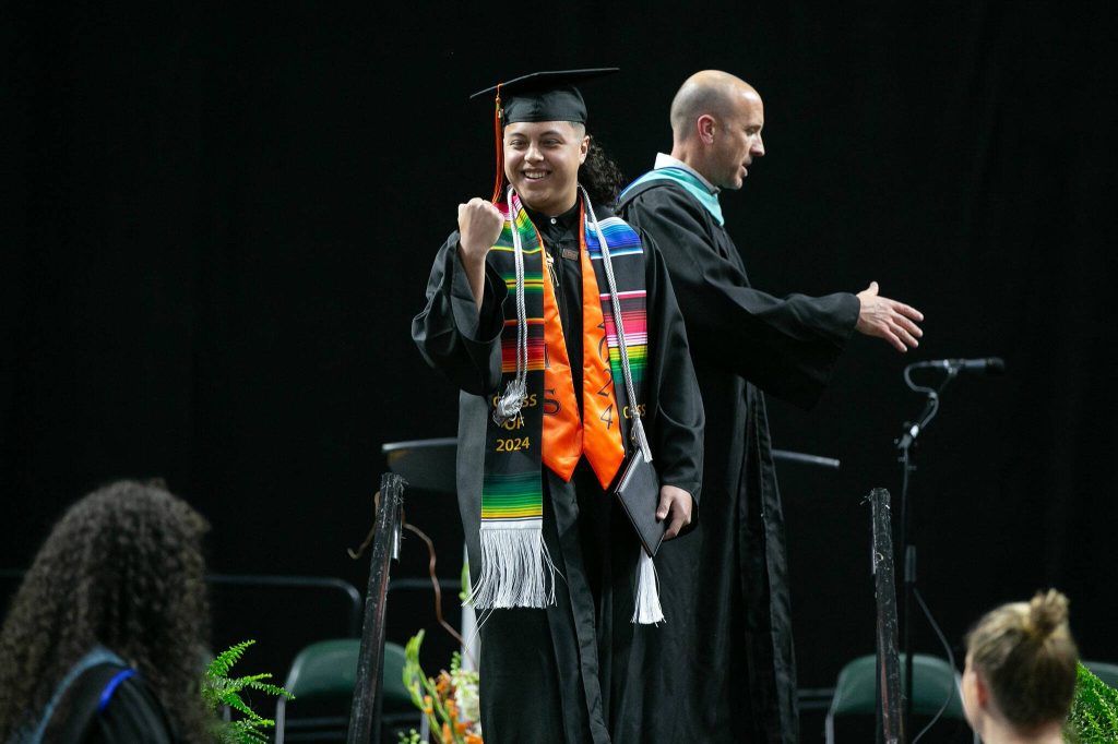 A graduate fist pumps after collecting a diploma onstage during Monroe High Schools 2024 commencement on Wednesday, June 12, 2024, at Angel of the Winds Arena in Everett, Washington. (Ryan Berry / The Herald)