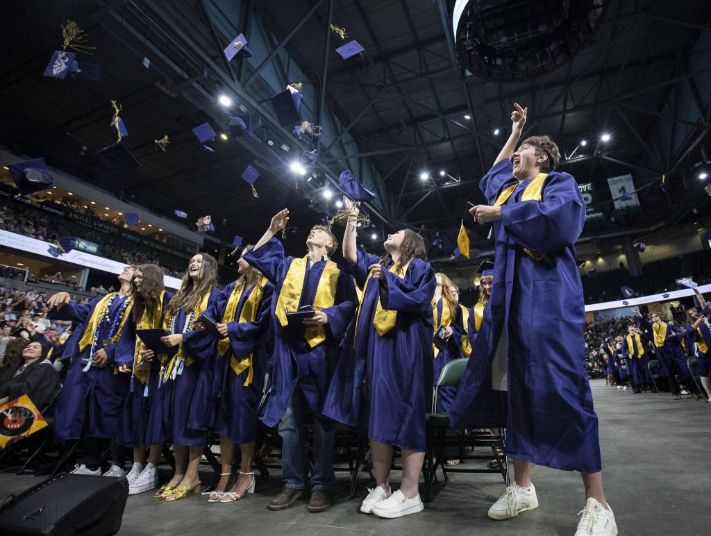 Graduates throw their caps in the air at the end of Arlington High School graduation at Angel of the Winds Arena on Thursday, June 13, 2024, in Everett, Washington. (Olivia Vanni / The Herald)