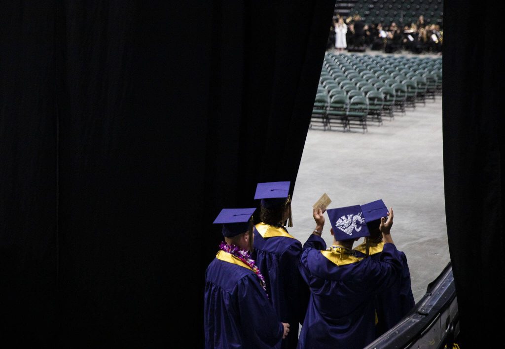 Students wave at family and friends before the start of Arlington High School graduation at Angel of the Winds Arena on Thursday, June 13, 2024, in Everett, Washington. (Olivia Vanni / The Herald)