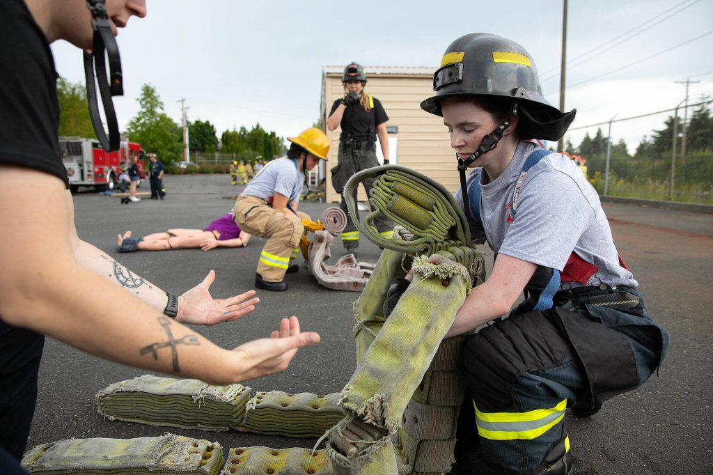 Firefighter hopefuls learn how to lift and carry a person during the Future Women in EMS/Fire Workshop on Saturday, June 22, 2024, at the South County Fire Training Center in Everett, Washington. (Ryan Berry / The Herald)