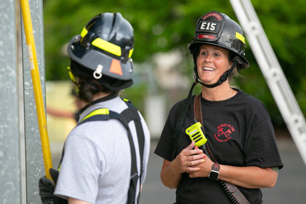 Veteran South County firefighter Melissa Beard, right, helps a participant through an exercise during the Future Women in EMS/Fire Workshop on Saturday, June 22, 2024, at the South County Fire Training Center in Everett, Washington. (Ryan Berry / The Herald)