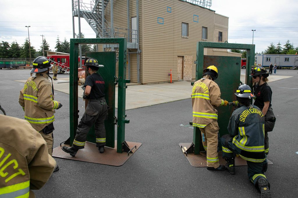 Instructors run a forced entry lesson during the Future Women in EMS/Fire Workshop on Saturday, June 22, 2024, at the South County Fire Training Center in Everett, Washington. (Ryan Berry / The Herald)