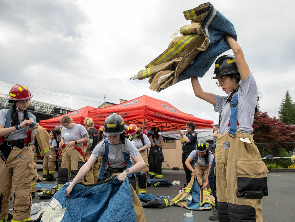 Firefighter hopefuls suit up during the Future Women in EMS/Fire Workshop on Saturday, June 22, 2024, at the South County Fire Training Center in Everett, Washington. (Ryan Berry / The Herald)