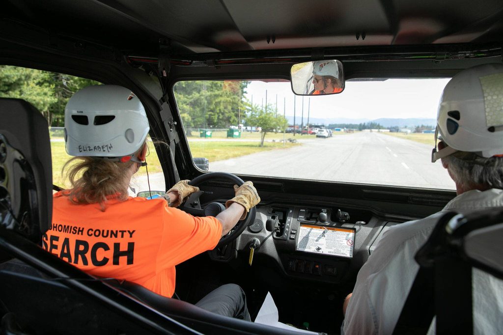 Snohomish County Volunteer Search and Rescue team members shuttle between locations in an all terrain vehicle during an interagency training session held by Northwest Regional Aviation on Thursday, June 13, 2024, at the Arlington Airport in Arlington, Washington. (Ryan Berry / The Herald)