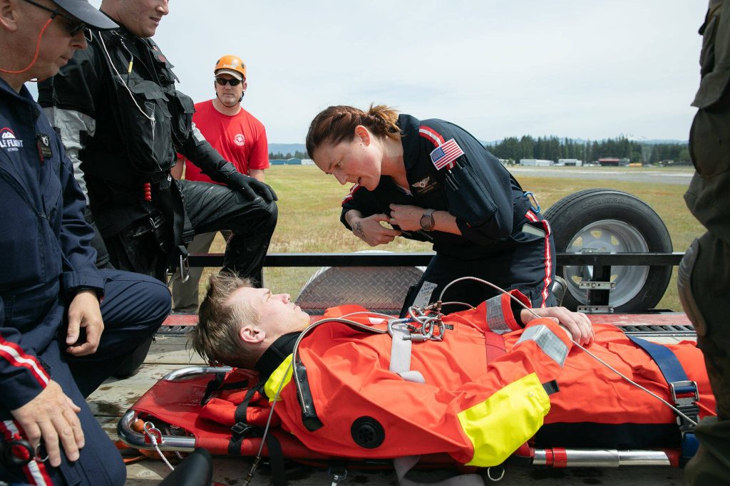 Flight Nurse Hannah MacIsaac from the Life Fight Network speaks with a simulated victim during transport as part of an interagency training session held by Northwest Regional Aviation on Thursday, June 13, 2024, at the Arlington Airport in Arlington, Washington. (Ryan Berry / The Herald)