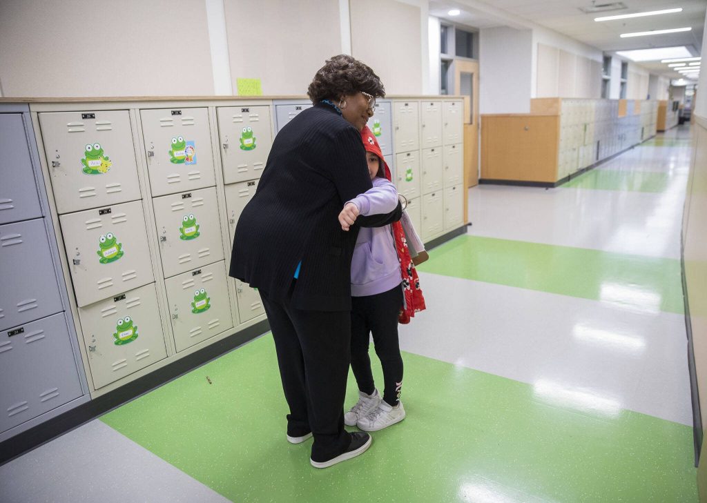 Principal Betty Cobbs receives a hug from second grade student Neela Zarrinabadi on Monday, June 17, 2024 in Bothell, Washington. (Olivia Vanni / The Herald)