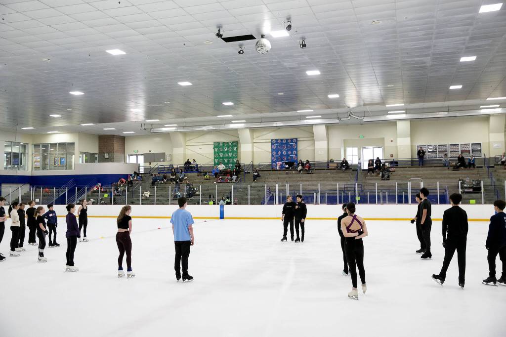 Students surround Jean-Luc Baker and Nathan Chen as they speak during the Seattle Skating Club 2024 Your True Step figure skating seminar on Saturday, June 15, 2024, at Olympic View Arena in Mountlake Terrace, Washington. (Ryan Berry / The Herald)