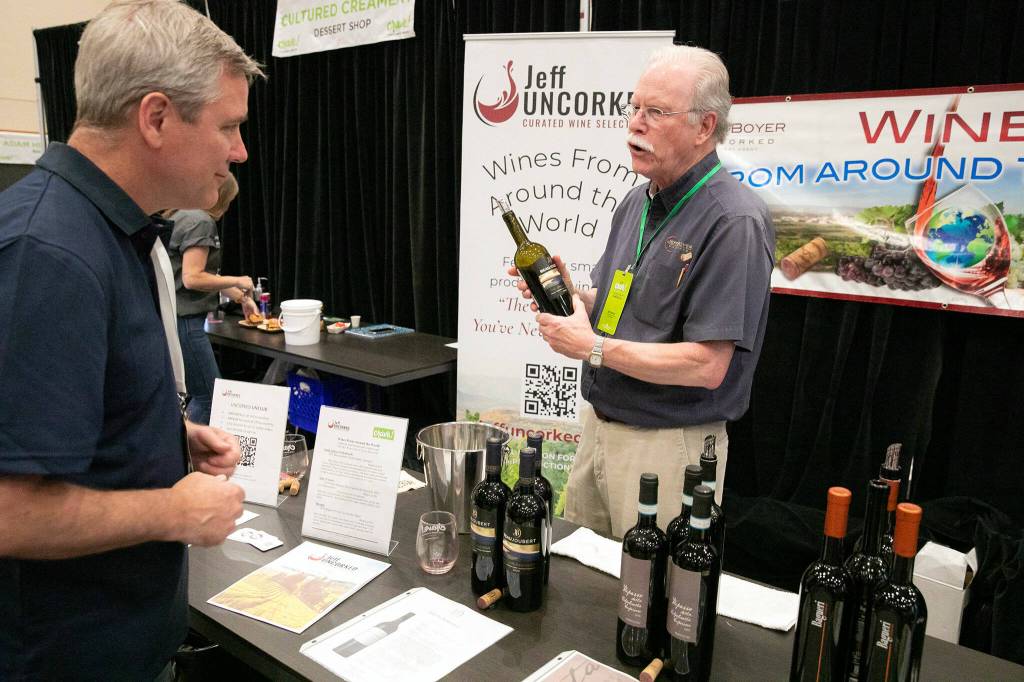 Jeff Boyer of Jeff UNCORKED, right, talks about his wine selection at Crave! Northwest food festival at the Lynnwood Event Center on Friday, June 21, 2024, in Lynnwood, Washington. (Ryan Berry / The Herald)